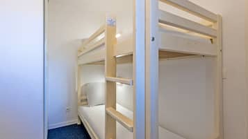 Une chambre avec un lit superposé, un mur blanc et une moquette bleue.