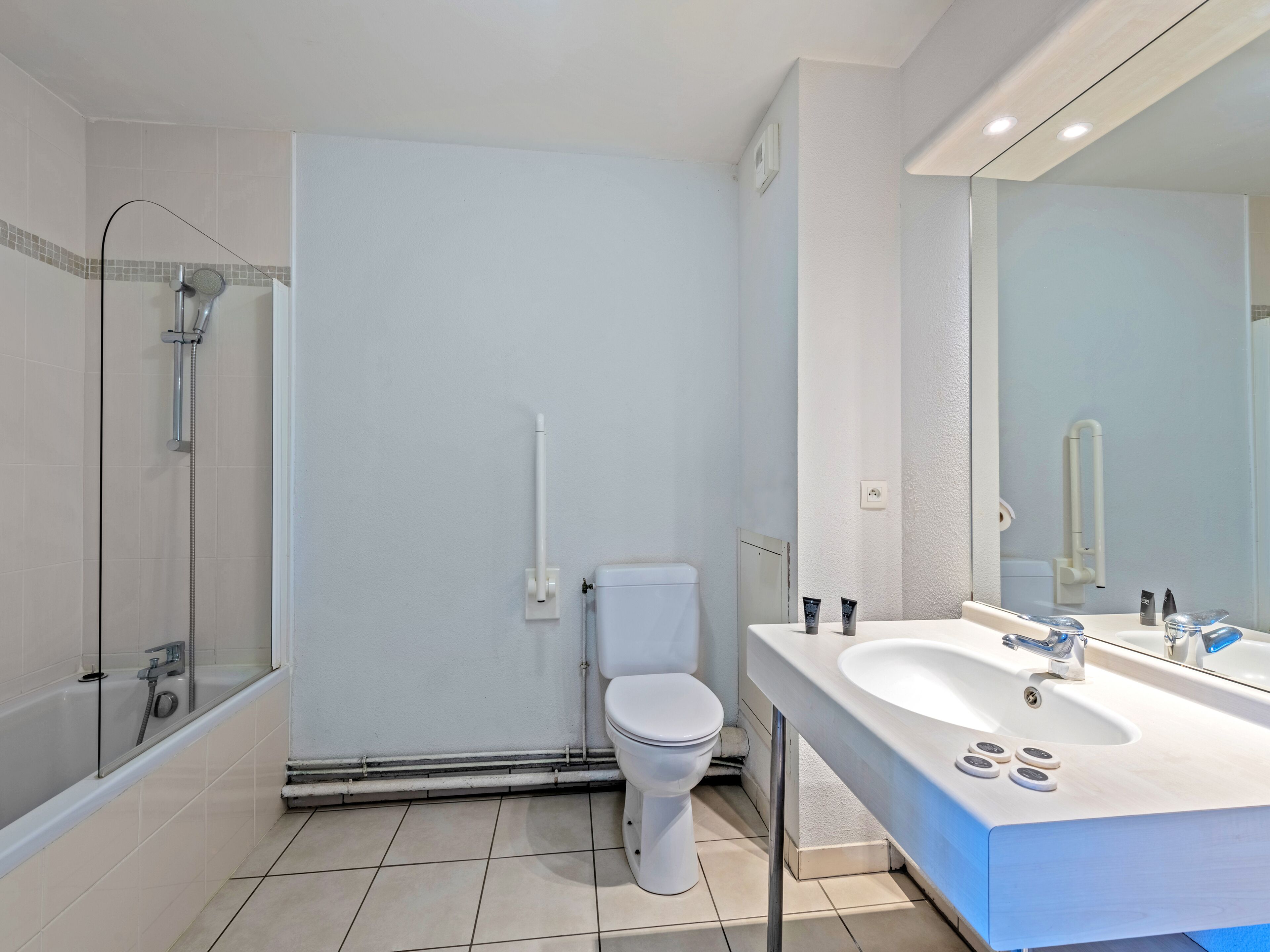 A modern bathroom with a shower, toilet, and sink.