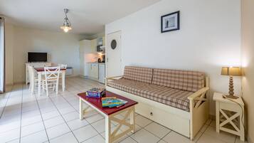 A compact living space with a kitchenette, a dining area, and a sofa.
