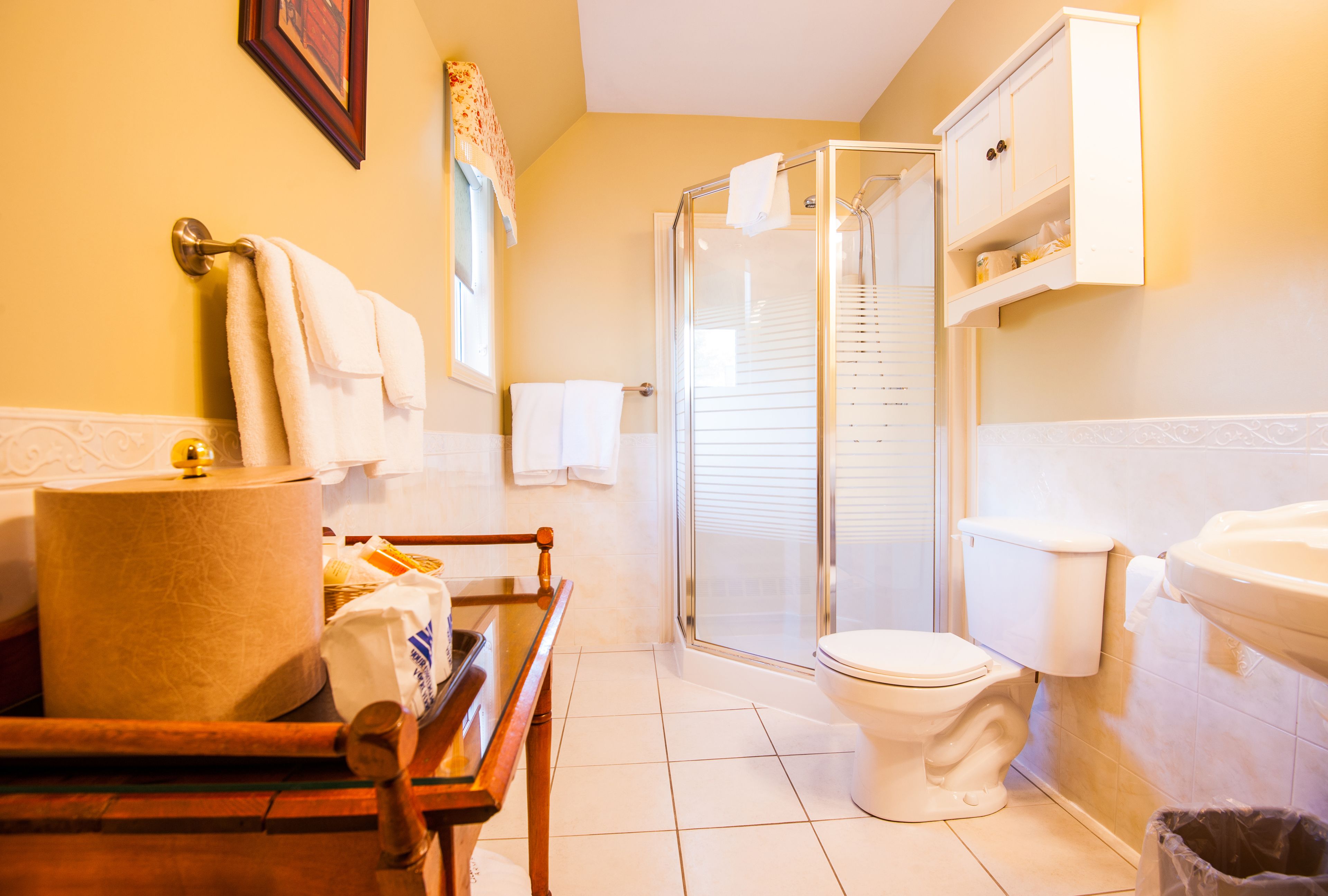 A bathroom with a toilet, shower, and sink.