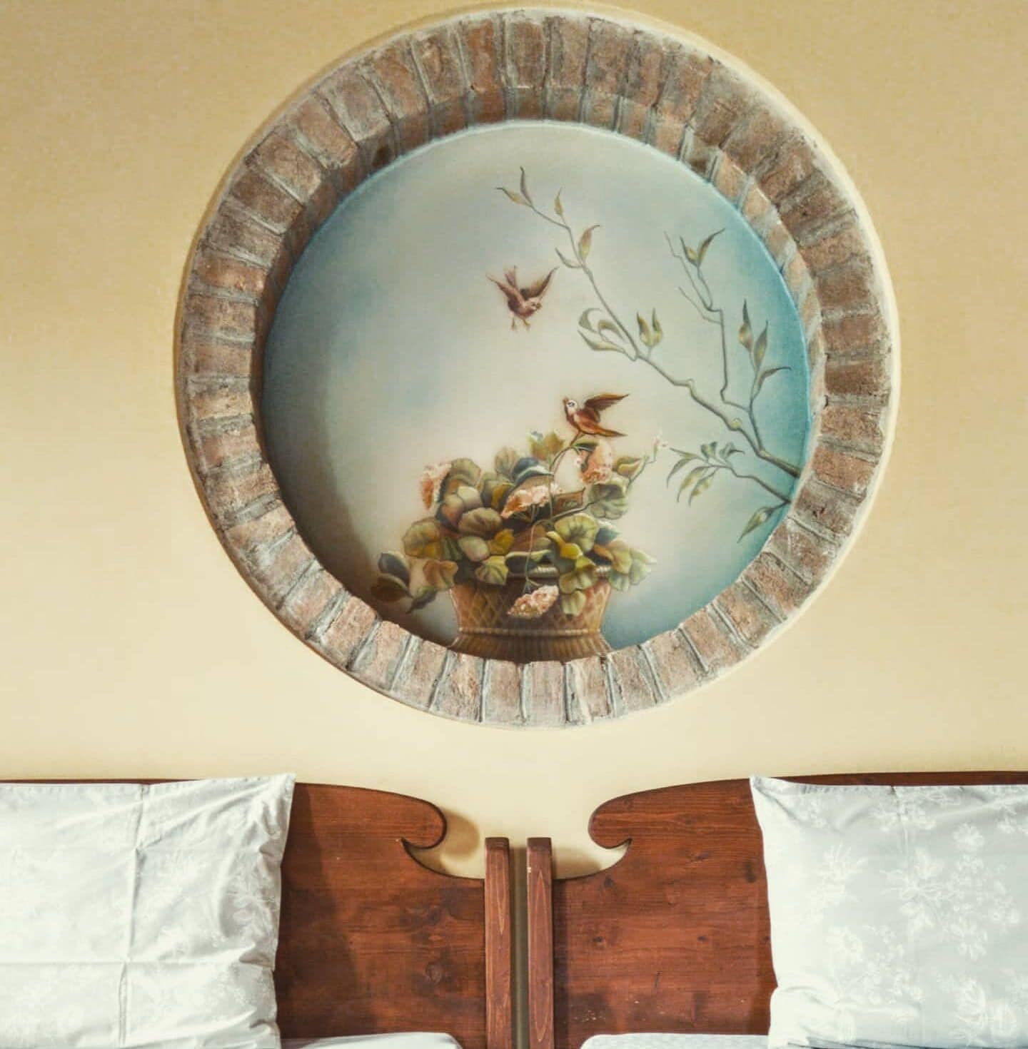 A wall-mounted decorative plate with a bird and floral design.