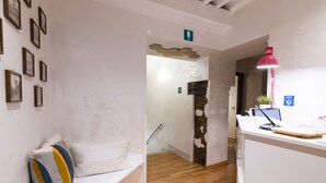 A reception area with a desk, a red lamp, and a wall with framed pictures. - Dulcis Inn Pantheon (Rome)