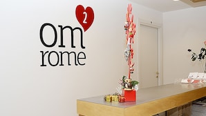 A reception desk with a sign reading "Om Rome 2" and a heart symbol. - OM2Rome (Rome)