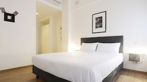 A neatly made bed with white linens in a hotel room. - OM2Rome (Rome)