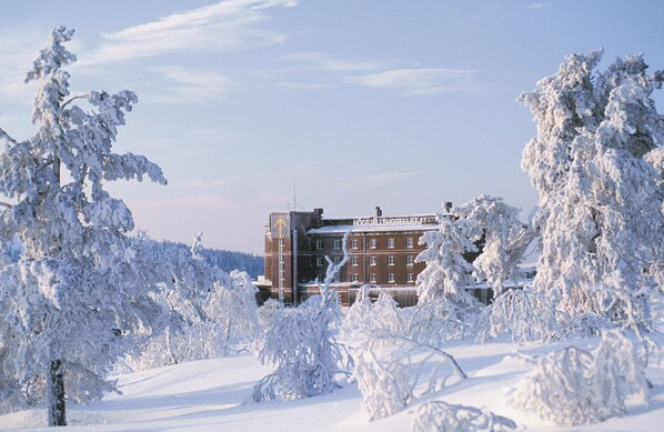 Un edificio cubierto de nieve con una entrada destacada y un letrero que indica un hotel.