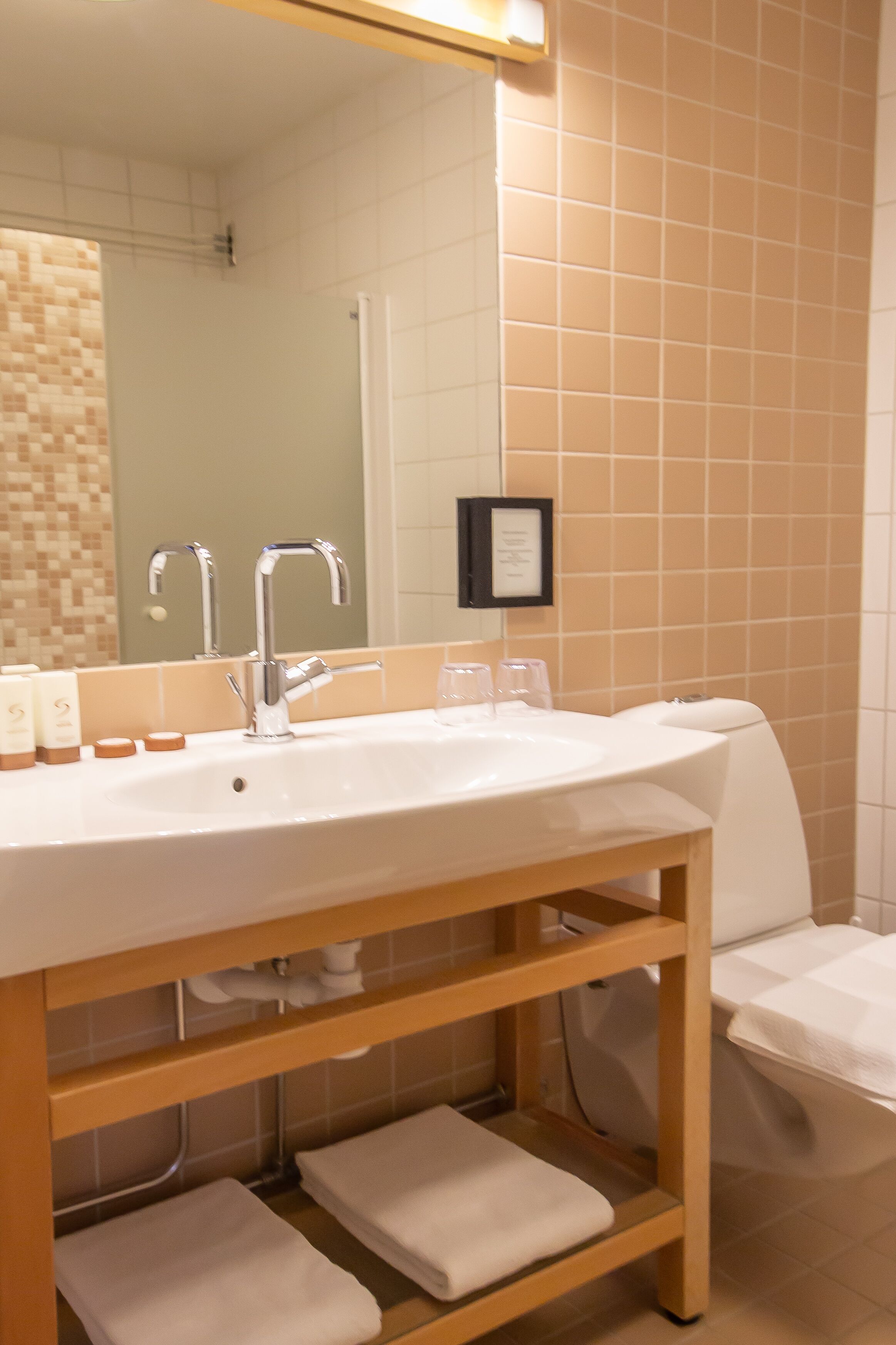 A bathroom with a large sink, mirror, and towel rack.