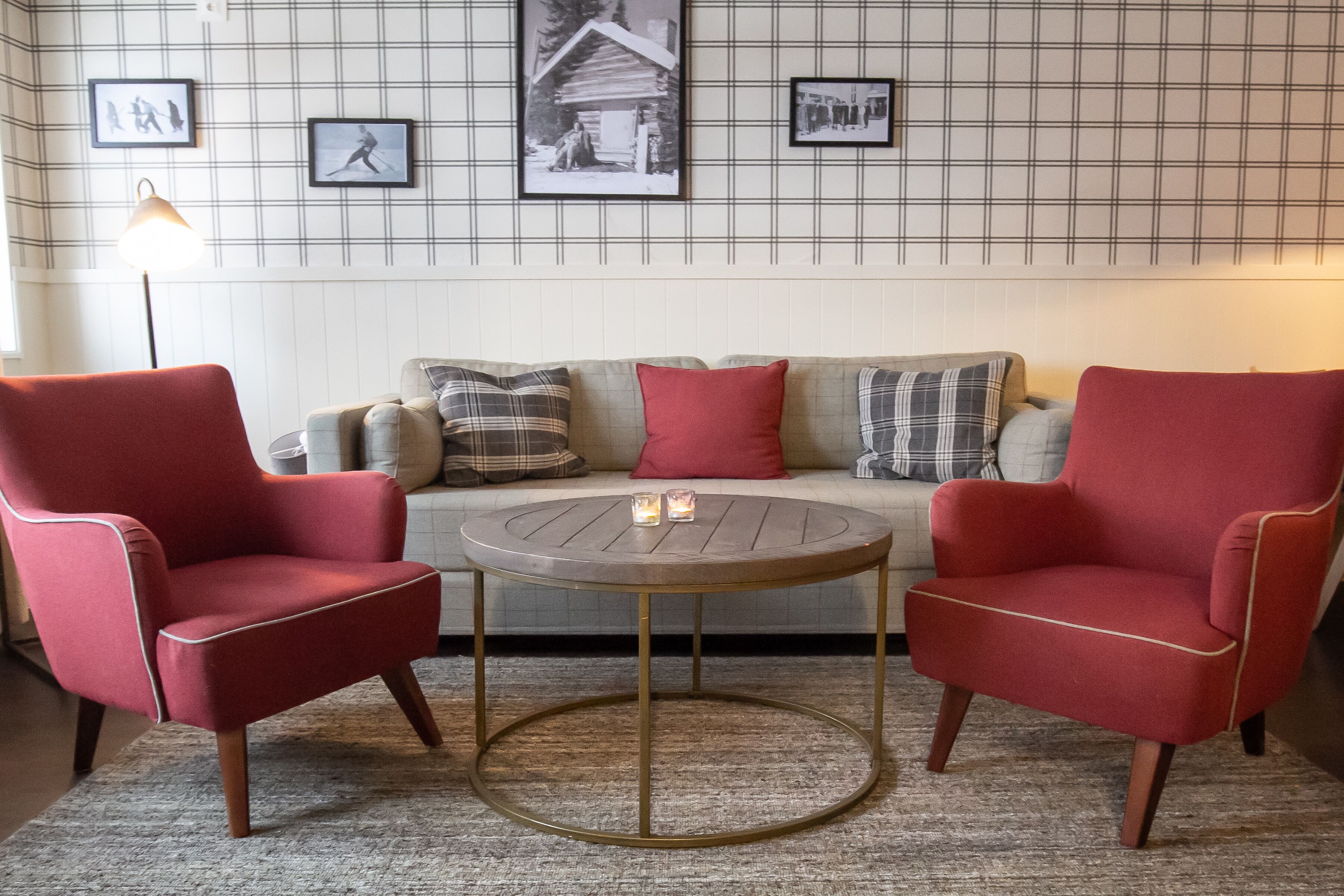 Un salon chaleureux avec un canapé, deux fauteuils et une table basse ronde.