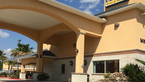 A hotel with a large canopy entrance, a sign for 'Scottish Inns & Suites', and a number '1615' on the building. - Scottish Inn & Suites (Houston)