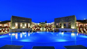 A large indoor swimming pool with multiple lounge areas and a central seating area.