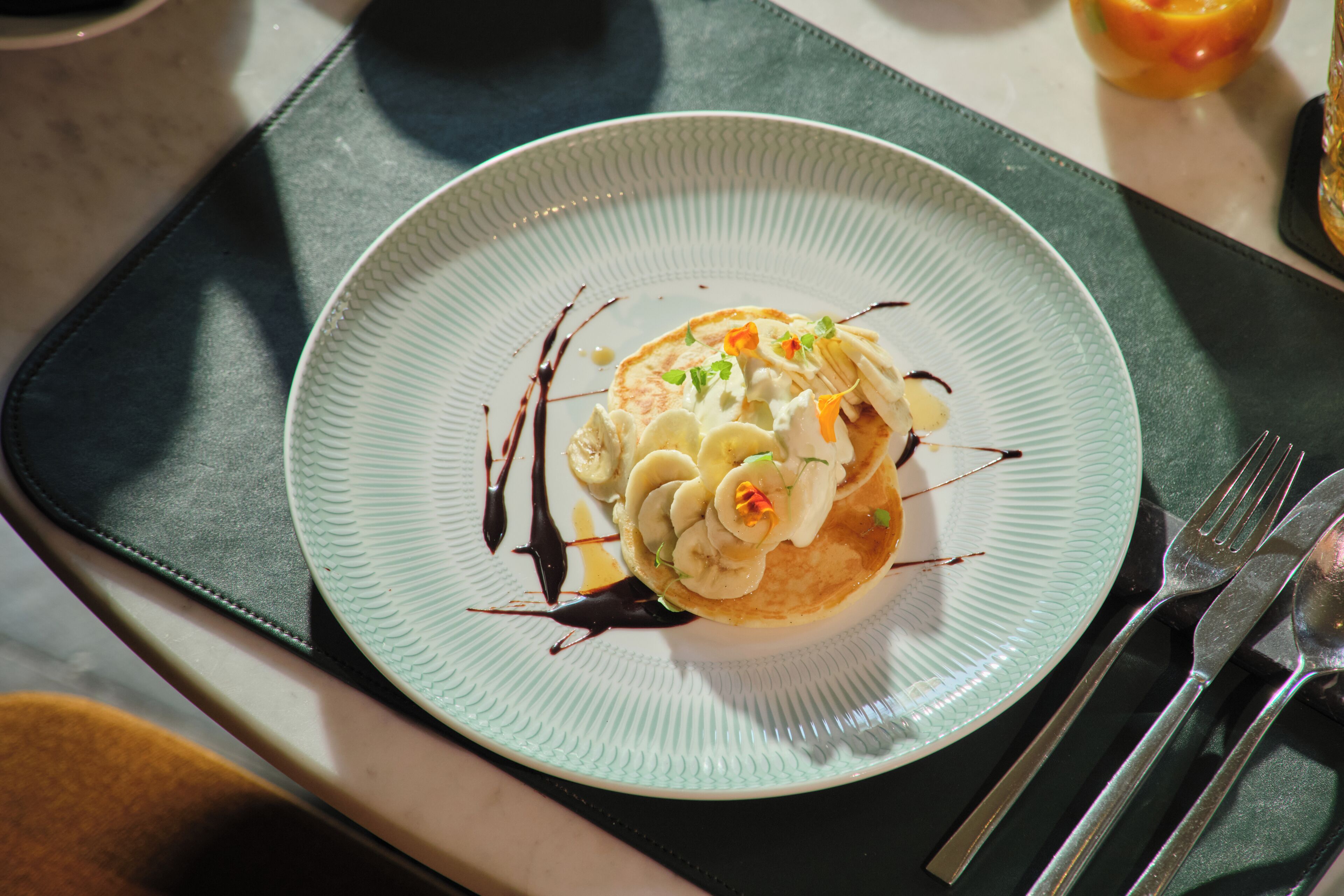 A plate of food on a table with a napkin and cutlery.