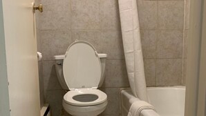 Ein Badezimmer mit Toilette, Badewanne und Duschvorhang.