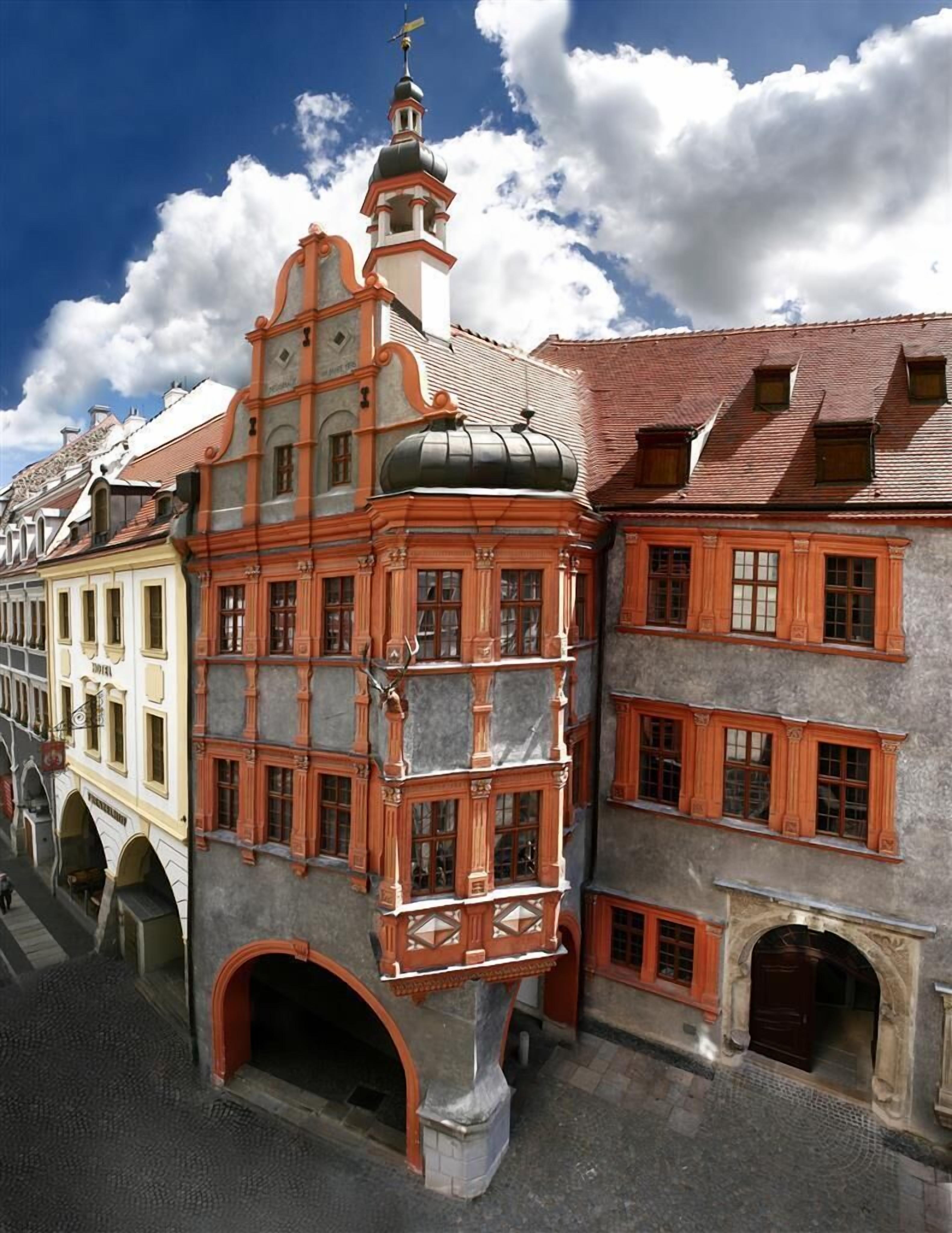 Un edificio histórico con una torre destacada y ventanas arqueadas.