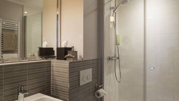 Een moderne badkamer met een douche met glazen wand, een wastafel en een spiegel.