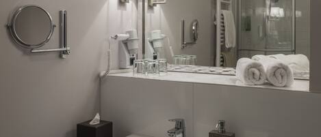 Un baño moderno con un espejo grande, un lavabo y un perchero para toallas.