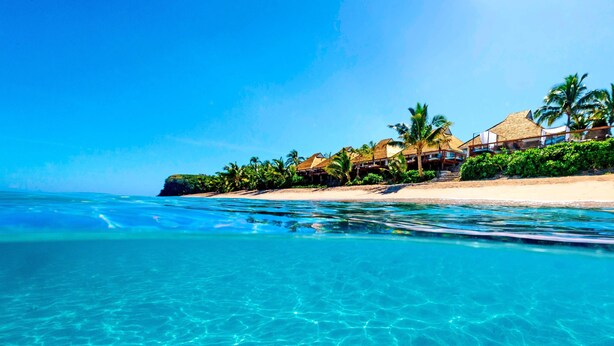A beachfront hotel with clear blue waters, palm trees, and a sandy beach. - Sheraton Resort & Spa, Tokoriki Island, Fiji (Tokoriki Island)