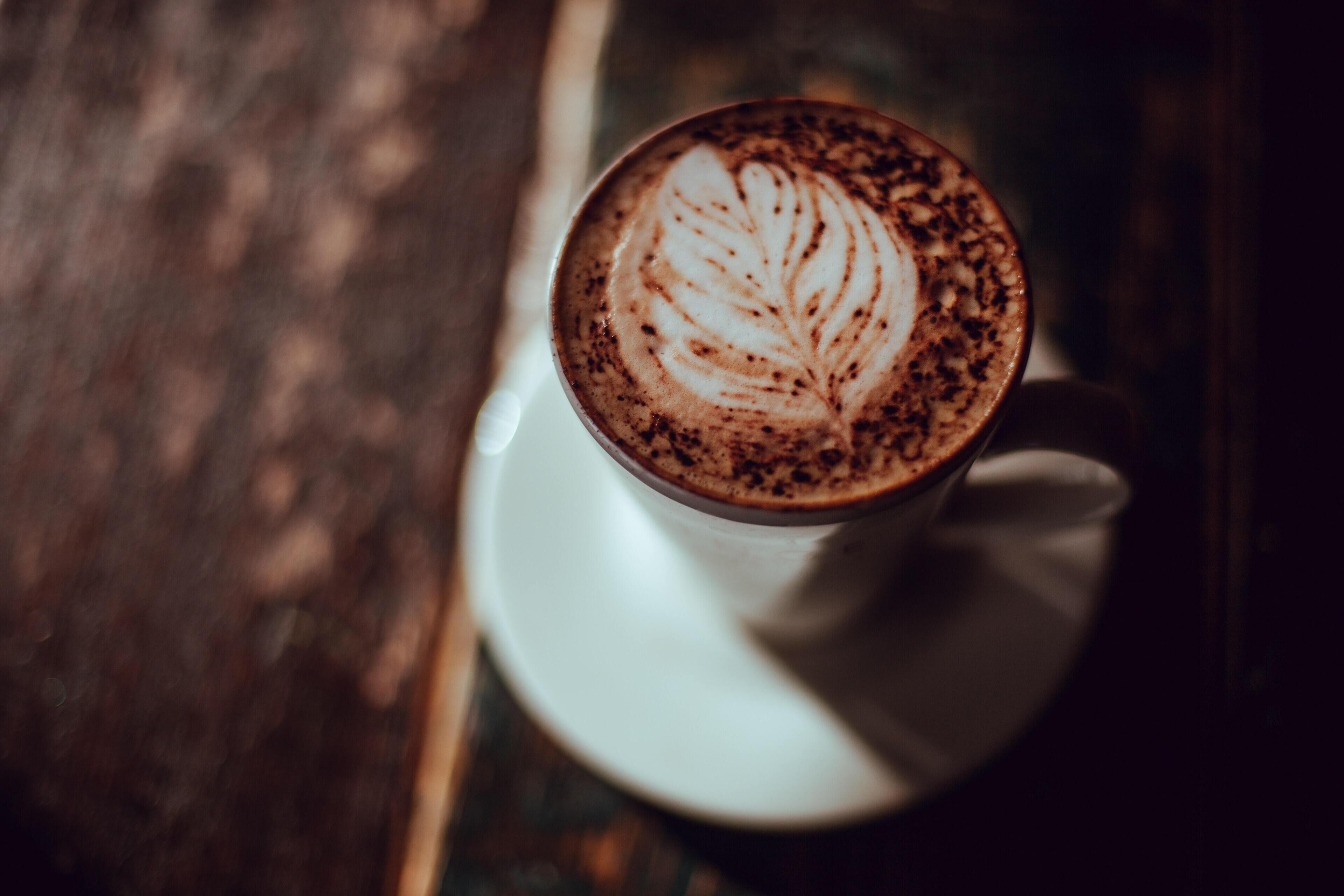 Eine Tasse Kaffee mit Latte-Art auf einem Untertasse.