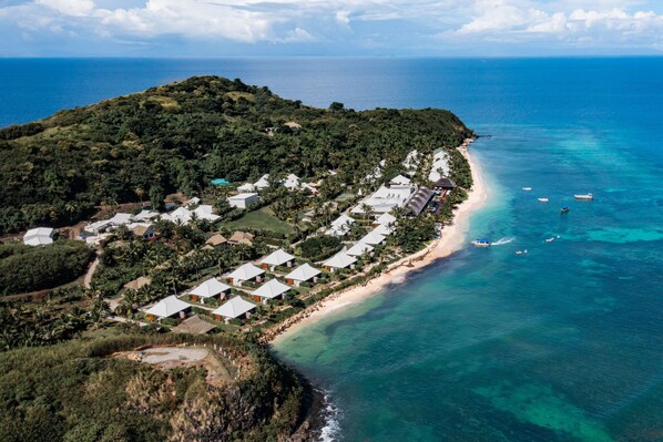 An aerial view of a coastal resort with multiple bungalow-style accommodations, a sandy beach, and clear blue waters. - Sheraton Resort & Spa, Tokoriki Island, Fiji (Tokoriki Island)
