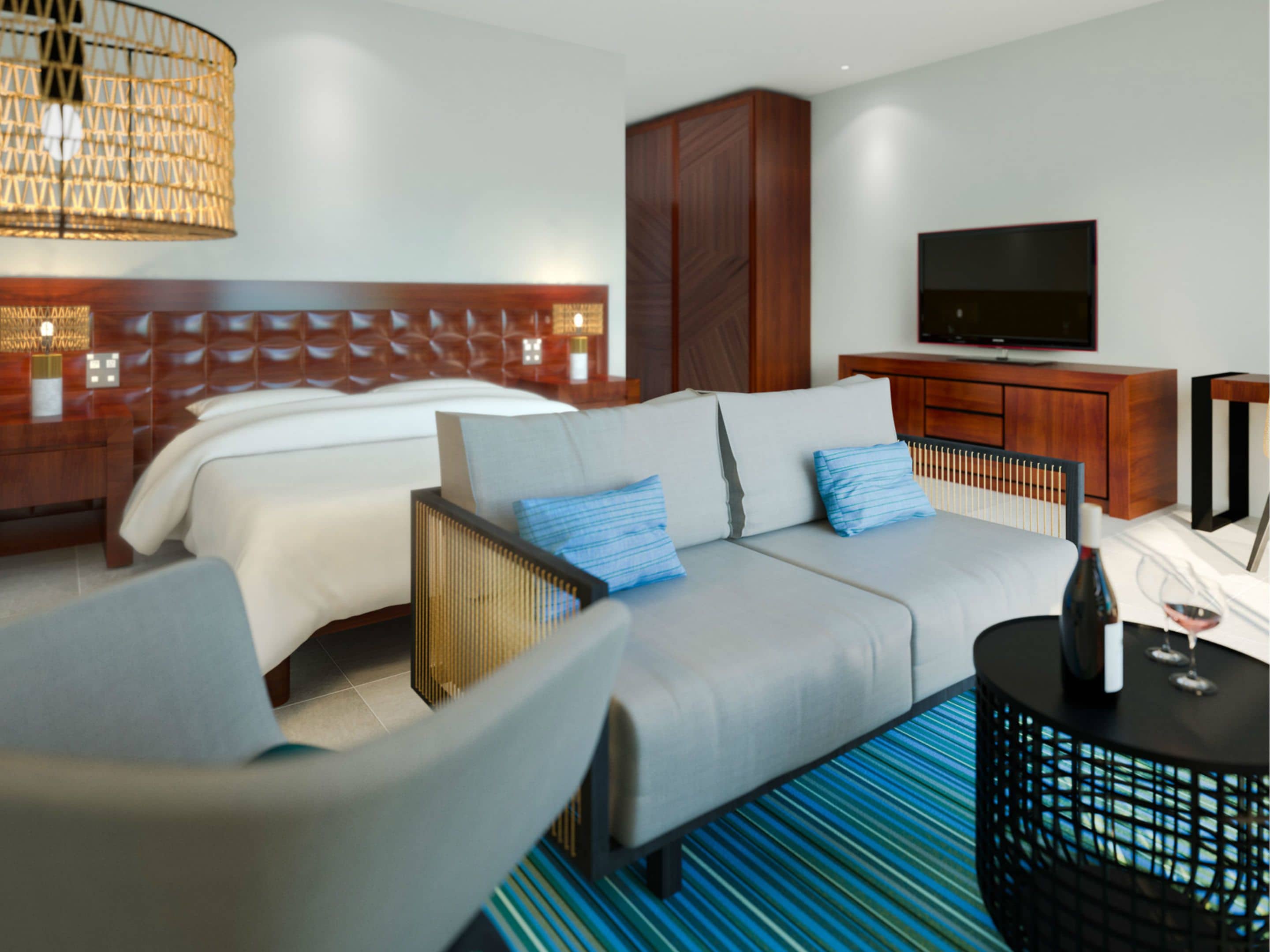 A modern hotel room with a large bed, a sofa, a TV, and a minibar.