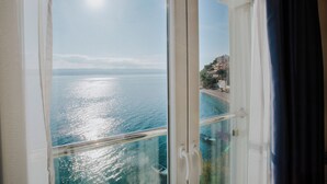 Une vue depuis un balcon donnant sur une étendue d’eau, avec une côte visible au loin.