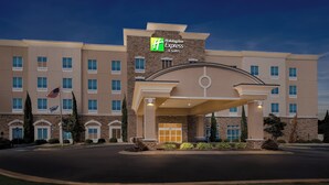 A Holiday Inn Express building with a modern design, featuring a prominent entrance and a flag.