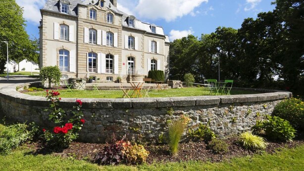 A large, historic building with a symmetrical facade, multiple windows, and a stone wall surrounding a landscaped garden. - Terres de France - Le Domaine de la Baie (Audierne)