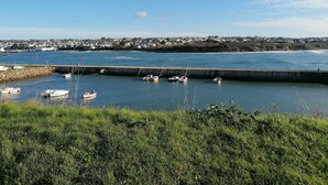 A coastal town with a harbor, boats docked, and a view of houses in the background. - Terres de France - Le Domaine de la Baie (Audierne)