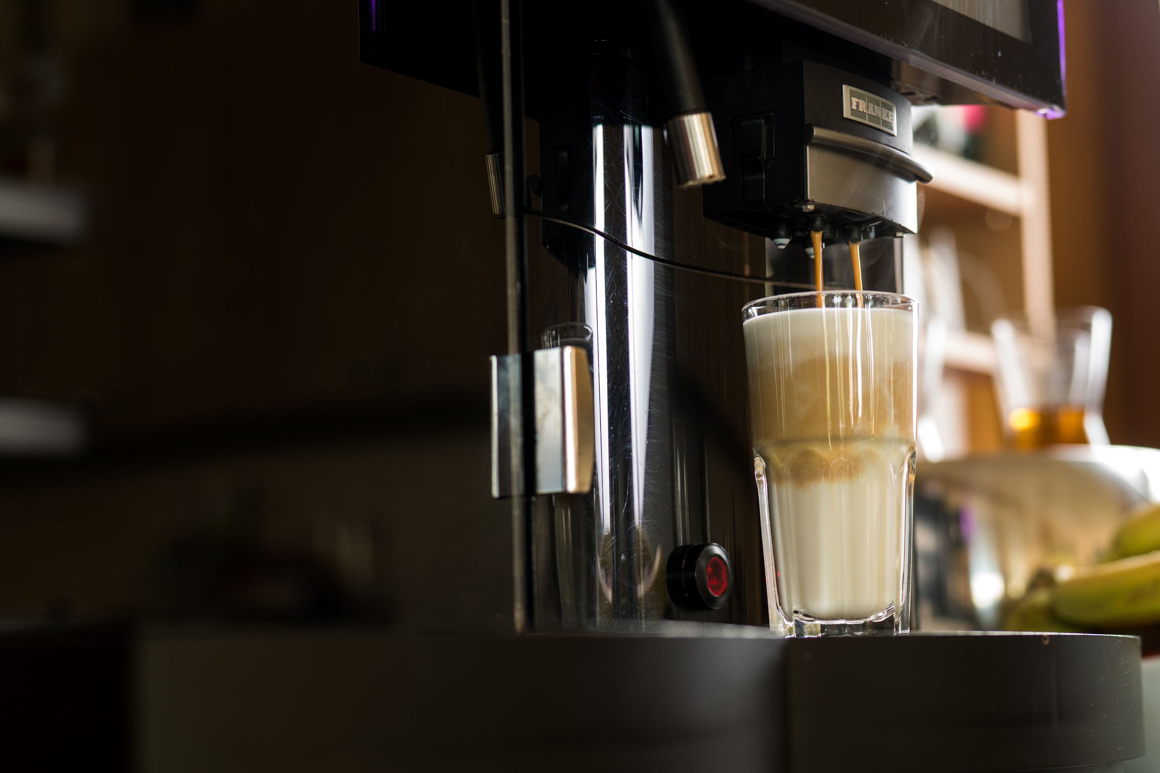 A coffee machine dispensing coffee into a glass.