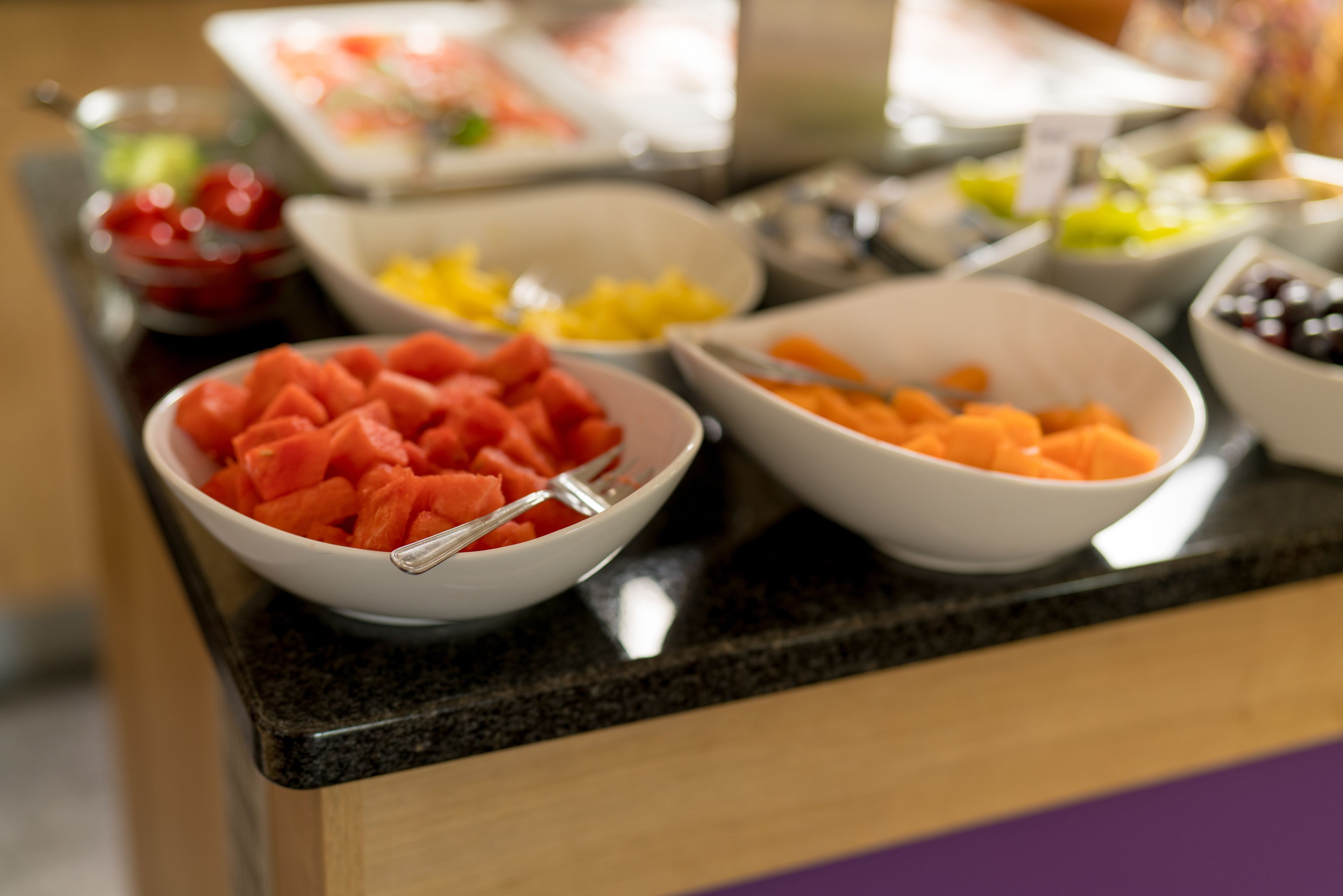 A buffet table with various fruits and vegetables.