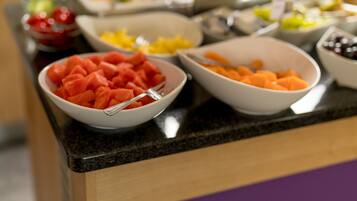 A buffet table with various fruits and vegetables.