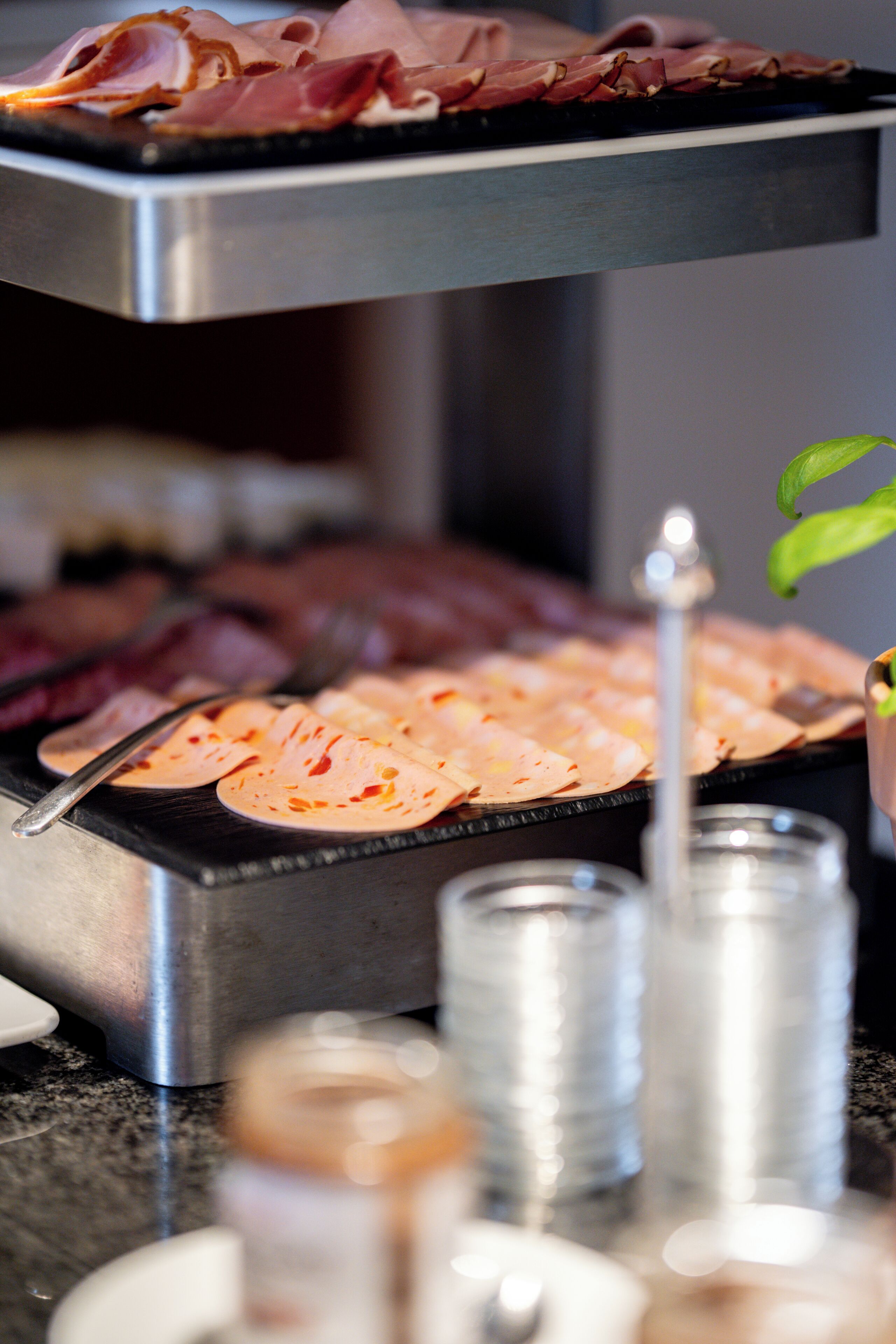 A buffet with various meats and a candle centerpiece.