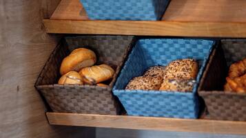 A kitchen counter with three blue baskets containing bread, stacked plates, and a knife.