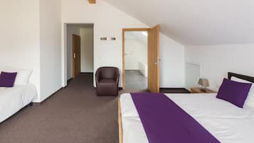 Une chambre à coucher moderne avec un grand lit, une chaise et une petite table.