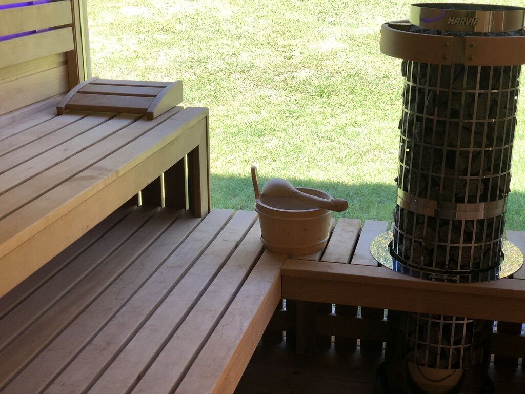 A wooden bench and a stone mortar on a patio.