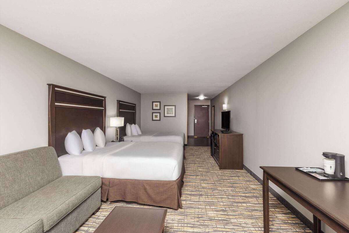 Een hotelkamer met een bed, een bank, een bureau en een televisie.
