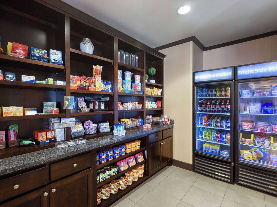 A well-stocked pantry with various food items and beverages, and two refrigerated display cases labeled "Bright Side Market".