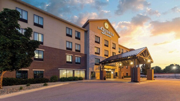 A La Quinta Inn & Suites building with a covered entrance and multiple windows.
