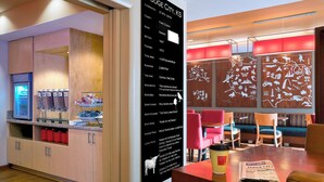 Un vestíbulo de hotel con recepción, zona de estar y una pared con información local sobre Dodge City, KS.