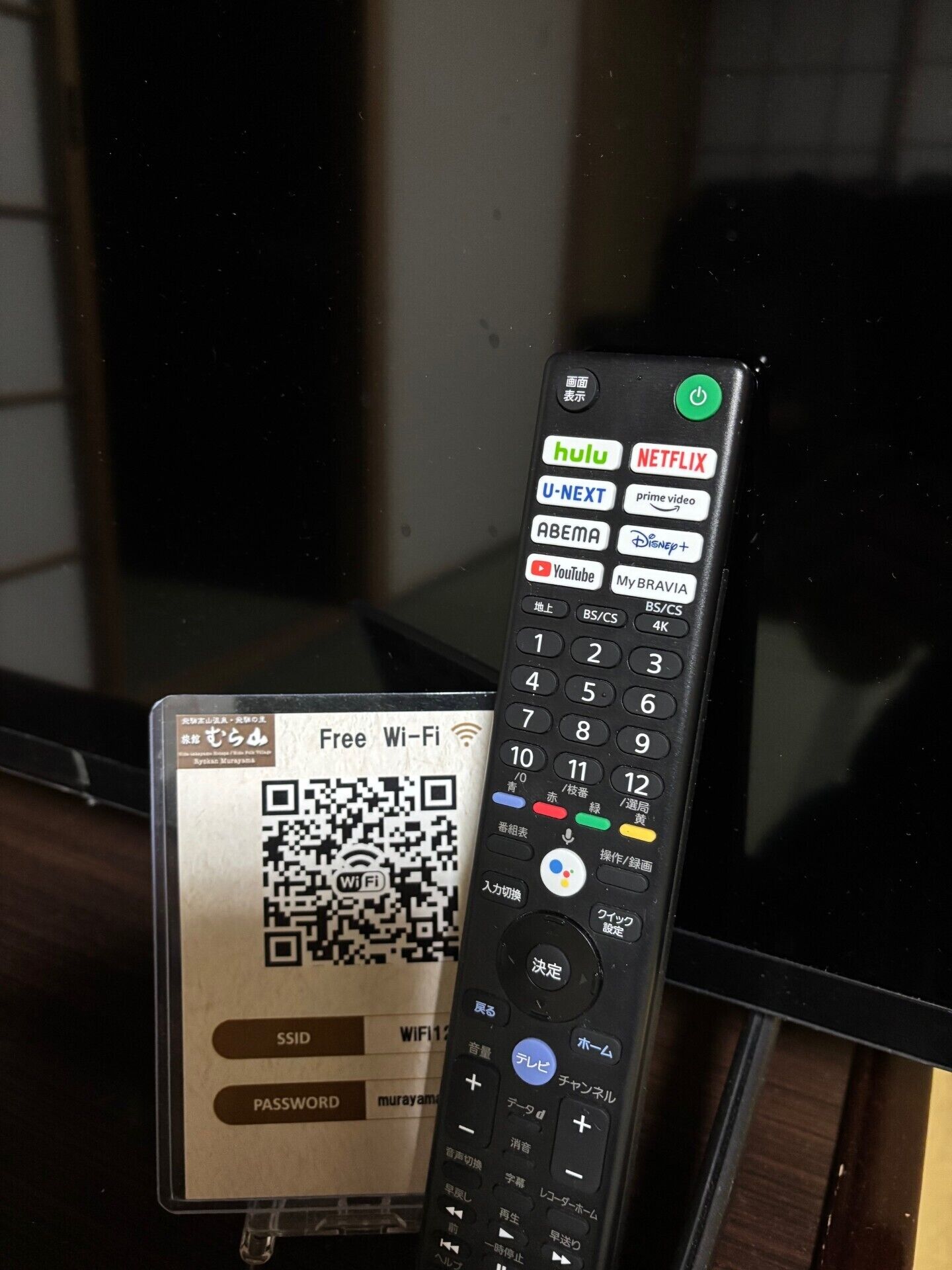 Un control remoto con un código QR y un letrero que indica Wi-Fi gratuito.
