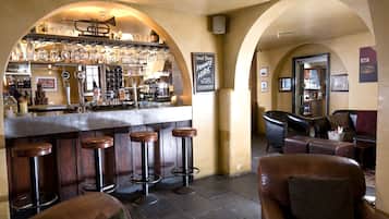 Uma área de bar com banquetas, balcão e uma placa que diz 'Great Times PRIVATE HIRE'.