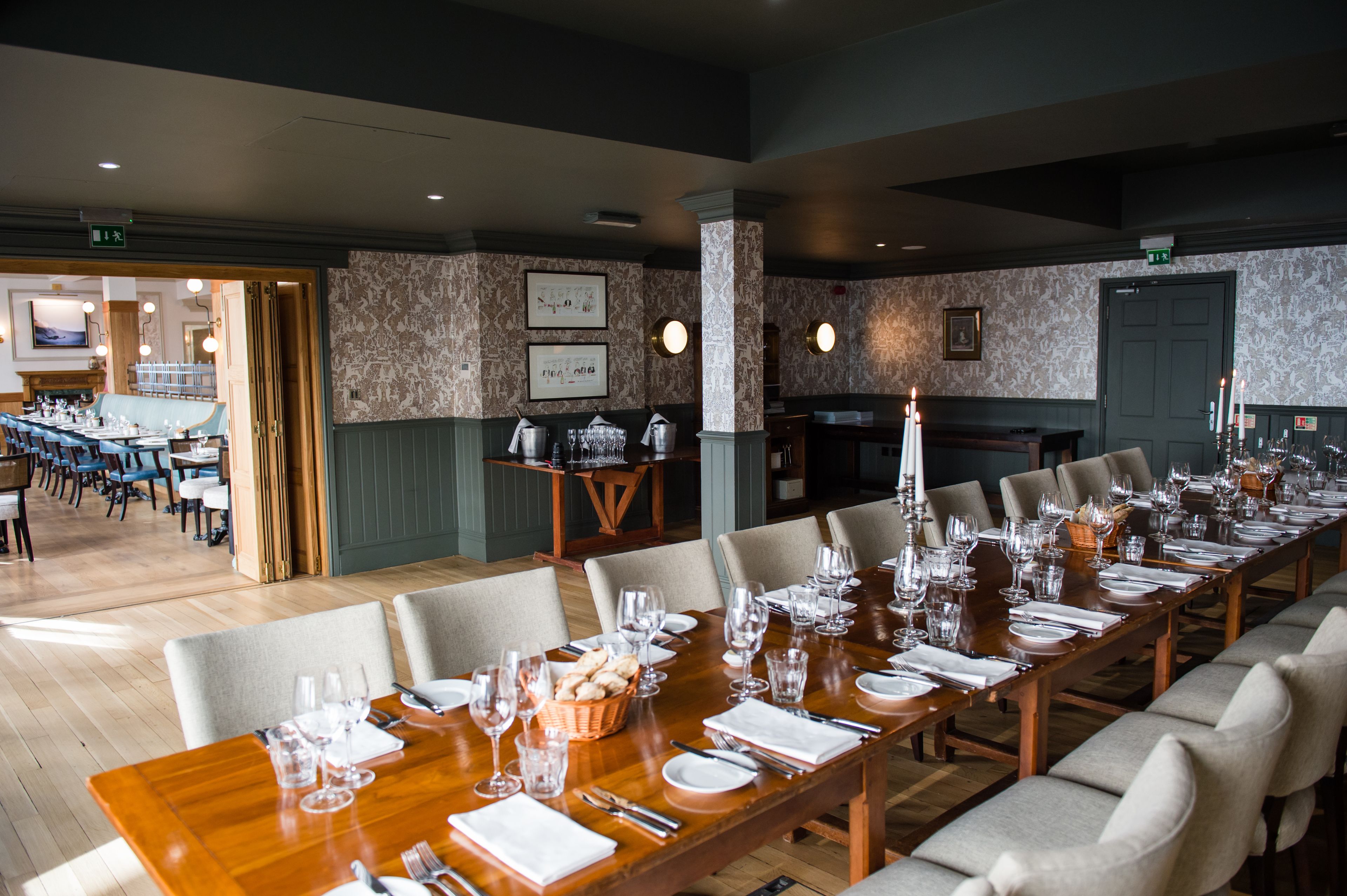 A long dining table set with chairs, a buffet area, and a fireplace.