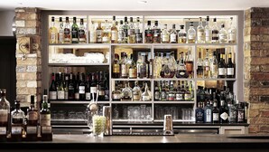 A bar area with shelves stocked with various liquor bottles and glasses. - Hotel du Vin & Bistro Cambridge (Cambridge)