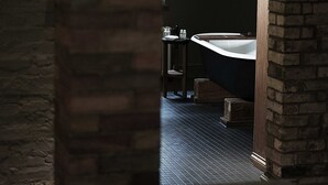 Une salle de bain avec une baignoire sur pieds, un miroir et un lavabo.