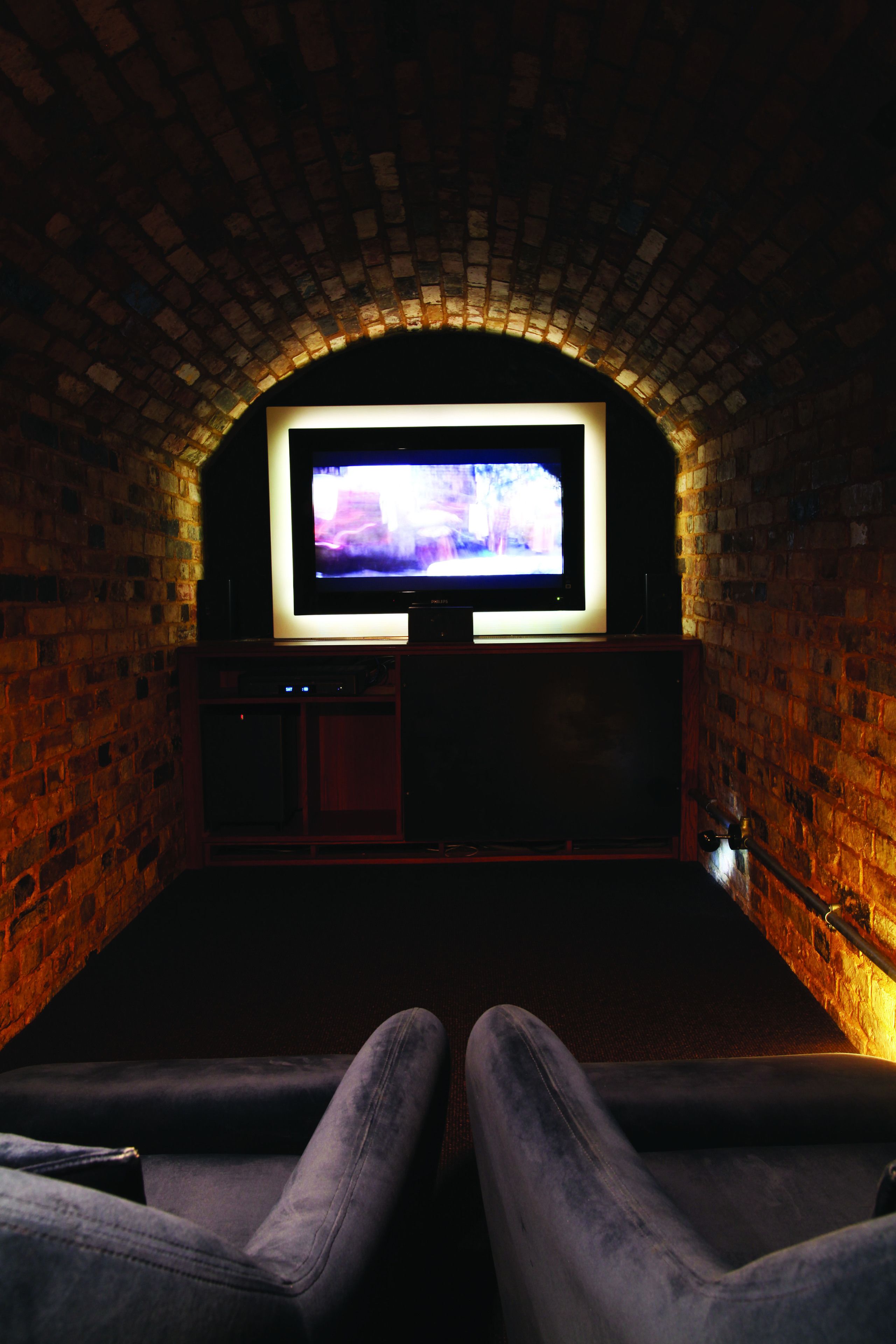 A cinema with brick walls and a large screen.
