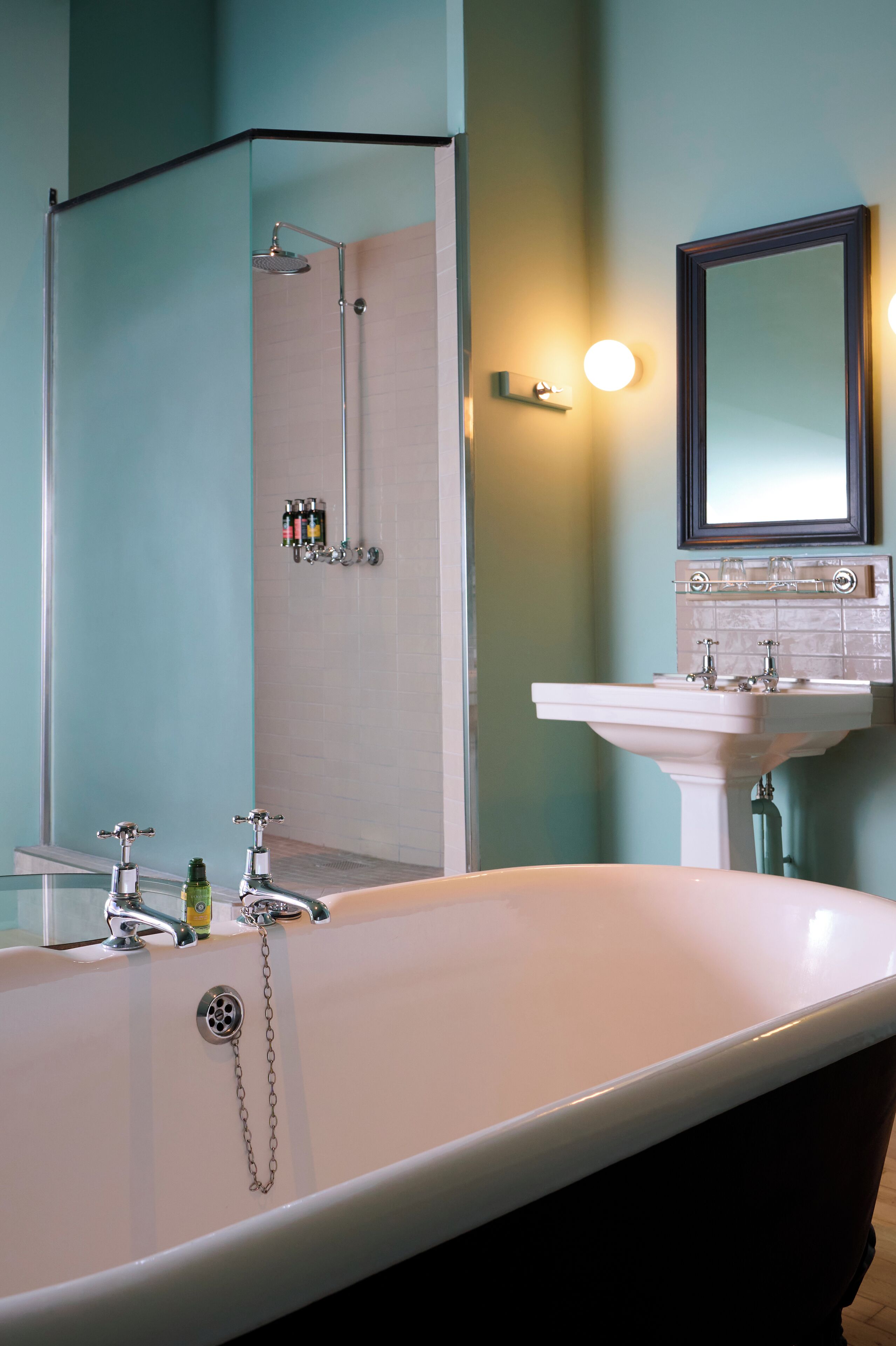 A bathroom with a freestanding bathtub, a shower, a sink, and a mirror.