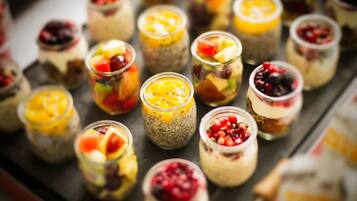 Una variedad de postres coloridos en pequeños frascos de vidrio.