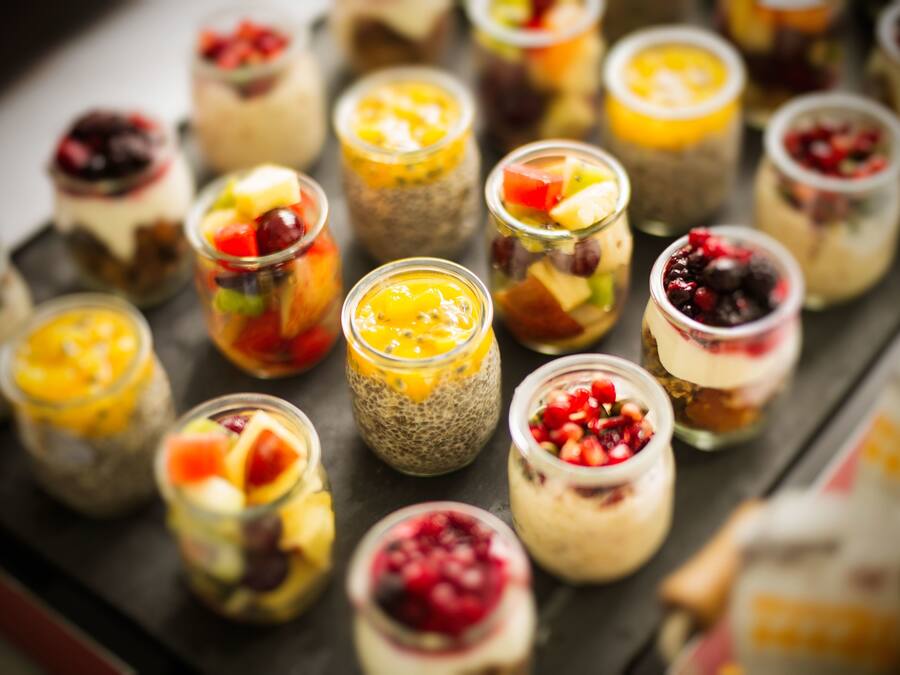 Una variedad de postres coloridos en pequeños frascos de vidrio.