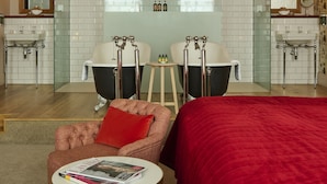 A hotel room with a large bed, two bathrooms, a sitting area with a magazine, and a red throw on the bed. - Hotel du Vin & Bistro Cheltenham (Cheltenham)