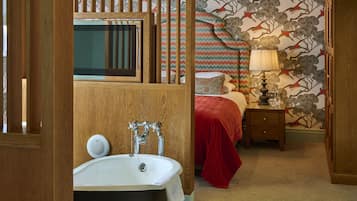 A bathroom with a bathtub, a mirror, and a wooden cabinet.