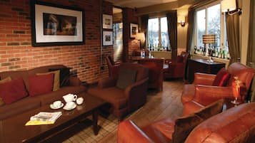Relax in a comfortable lounge area with sofas, armchairs, and a bar, perfect for socializing or unwinding.
