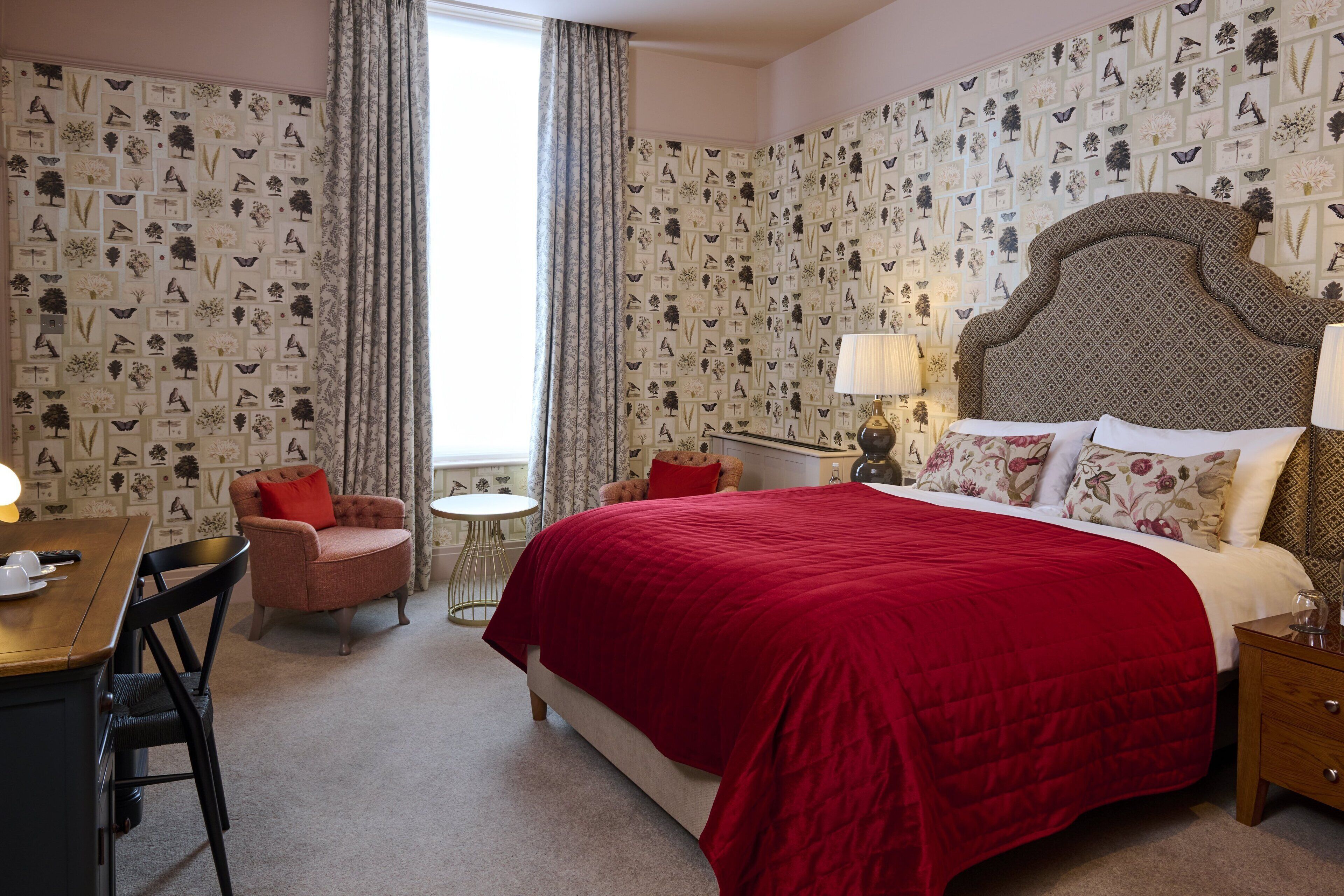 Une chambre d’hôtel avec un grand lit, un bureau, une chaise et une petite table.